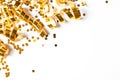 Shiny golden serpentine streamers and confetti on white background, top view