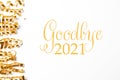 Shiny golden serpentine streamers and phrase Goodbye 2021 on white background, top view