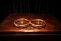 Shiny golden wedding rings on a wooden surface Royalty Free Stock Photo