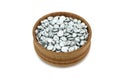 Shiny granules of zinc in a wooden bowl