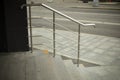 Shiny gray curved metal railings on the stairs, exit from the store. Urban infrastructure. The street of the metropolis in
