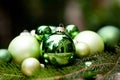 Shiny green christmas baubles closeup macro and tree