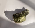 Shiny green muscovite mica mineral sheet on white background. Found in Miass, Ural, Russia. For geology mineralogy