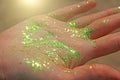 A shiny hand in glitter on the sun. Brilliant green hands, magic in the sun