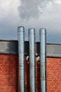 Shiny metal chimneys and vent pipes on a roof