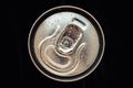 Shiny metal cola can lid with water drops on black background. Golden bottle of drink, lid of packaging of beer. Top view