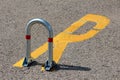 Shiny metal fold down vehicle security car parking lock safety barrier mounted on paved parking lot with reserved sign painted on Royalty Free Stock Photo