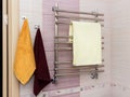 Shiny metal heated towel rail set in the bathroom dry towel.