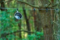 A shiny metal mug is hanging on a hook in the woods by a tree. A rope is stretched between the trees around the tent camp. Tourist Royalty Free Stock Photo