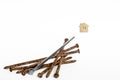 A shiny metal nail lies on a pile of old rusty nails and is aimed at the house symbol on a white background. Royalty Free Stock Photo