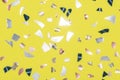 shiny metallic confetti on a bright yellow background