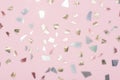 shiny metallic confetti on a pastel pink background