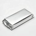 Shiny metallic foil-wrapped rectangular object on a plain background Royalty Free Stock Photo