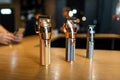 Shiny metallic vintage hair trimmers stand on a wooden table in a men`s hair salon. Male barbershop.