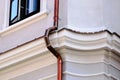 shiny new copper gutter and rain water leader, downspout or down pipe detail on historic stucco exterior wall Royalty Free Stock Photo