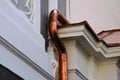 shiny new copper rain water leader, downspout or down pipe detail on historic stucco exterior wall Royalty Free Stock Photo