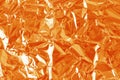Shiny orange foil texture background, pattern of wrapping paper with crumpled and wavy Royalty Free Stock Photo