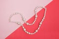 Shiny pearl necklace on pink background Royalty Free Stock Photo