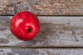 Shiny pomegranate on wooden backdrop.