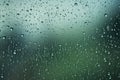 Shiny raindrops splashes falling cascading down wet glossy foggy glass window car outdoor during rainy stormy day Royalty Free Stock Photo