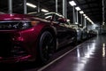 a shiny raspberry-colored car among sleek black cars