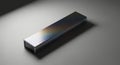 Shiny rectangular metal object reflecting subtle colors on a textured surface Royalty Free Stock Photo