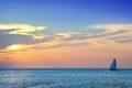 shiny sea and sailboat over cloudy sky and sun during sunset in Cozumel, Mexico Royalty Free Stock Photo