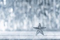 Shiny silver christmas star with defocused christmas lights in the background. Christmas background.