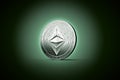 Shiny silver Ethereum classic concept coin on gently lit dark gr