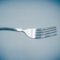 Shiny silver fork close-up in blue space Royalty Free Stock Photo