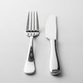 Shiny silver fork and knife rest side by side on a white textured tablecloth Royalty Free Stock Photo