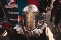 Shiny silver medieval iron knight helmet with a golden cross, full of scratches due to battles