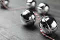 Shiny silver sleigh bells on grey stone table, closeup. Space for text Royalty Free Stock Photo