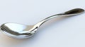 Shiny silver spoon lying on a white tablecloth Royalty Free Stock Photo