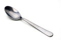 Shiny silver spoon resting on a clean white surface reflecting gentle light Royalty Free Stock Photo