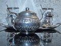 A shiny silver teapot and glasses on a tray. Cooking battery. Royalty Free Stock Photo