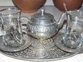 A shiny silver teapot and glasses on a tray. Traditional tea party in the Eastern style. Cooking battery. Royalty Free Stock Photo