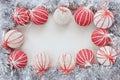 Shiny silver tinsel with white and red Christmas balls borders a blank white background. Top view