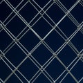 Shiny silver wire mesh forms a diamond pattern against a dark blue background. The Royalty Free Stock Photo