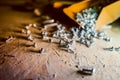 Shiny small self-tapping screws bugs scattered from the box on the floor close-up Royalty Free Stock Photo