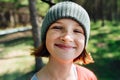 Shiny smiling freckled ginger girl in the woods on a sunny day