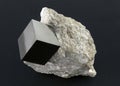 Shiny smooth regular shape pyrite cube on a dark background