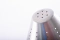 Shiny stainless steel metallic detail strainer isolated in a white minimalist kitchen