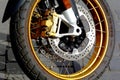 Shiny steel front brake disc detail on large motorcycle wheel