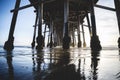 Shiny sun under the pier over reflecting water at Newport Beach, California Royalty Free Stock Photo