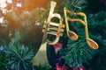 Shiny treble clef ornament or gold music notes hanging on pine tree. Stylish christmas decorations. Christmas and New Year display