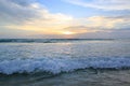 Shiny tropic sea wave on golden beach sand in sunset light