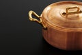 Shiny vintage copper cookware over dark background Royalty Free Stock Photo