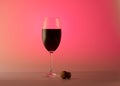 Shiny wineglass half red wine pink background Royalty Free Stock Photo