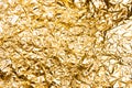 Shiny wrinkled gold foil abstract texture background.